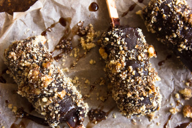 istock ice cream stick with nut almonds on dark background , Flat lay / ice cream covered chocolate sticks frozen Popsicle and Lolly sweet dessert 1196570851