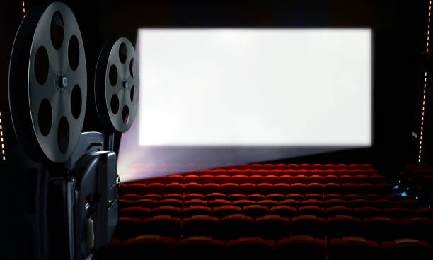 istock Projector in cinema hall with blank white screen 1196571623