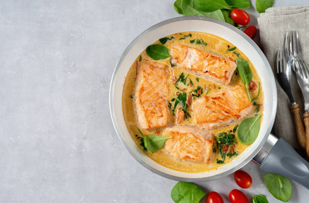 istock Delicious salmon steaks in cream sauce on light background 1196576685