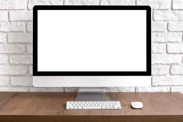 istock Mock up blank screen computer desktop with keyboard and mouse on wooden table. Work place concept. 1196580931