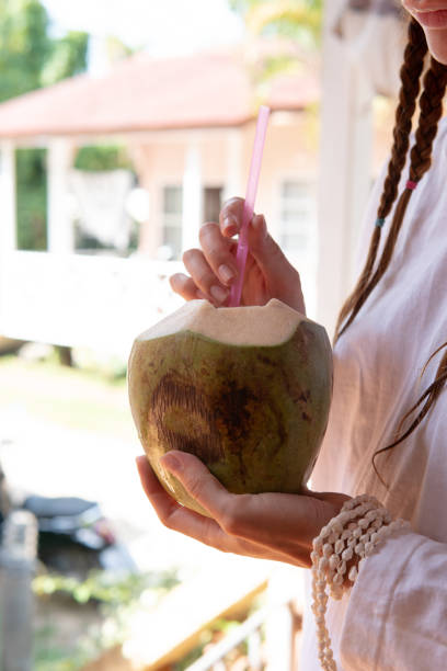 istock drinking coconut in female hands close up. 1196582608