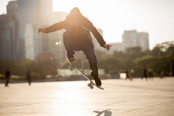 istock Skateboarder skateboarding at sunset city 1196585926
