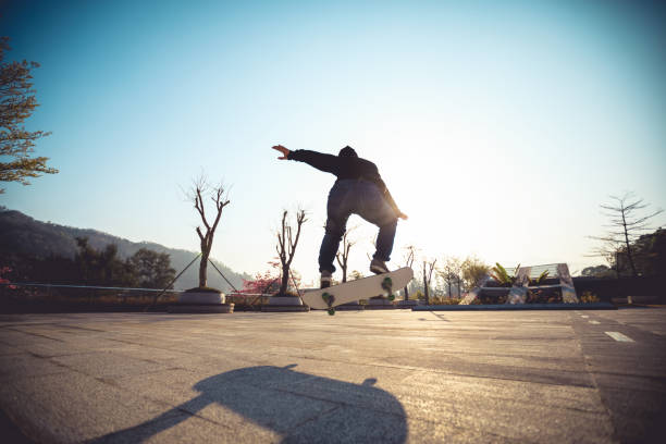 istock Skateboarder skateboarding at sunrise city 1196590314