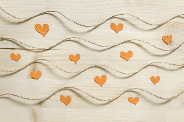 istock Valentines day pattern with wavy rope, small fabric hearts on wooden backgound 1196593245