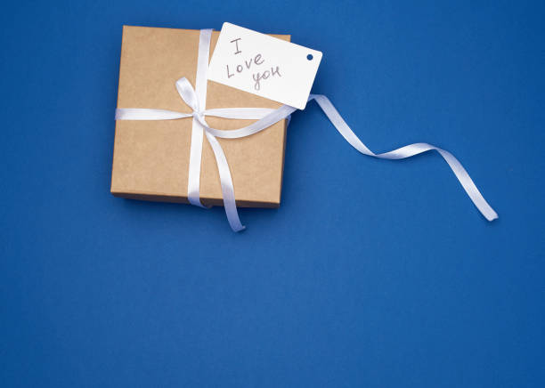 istock brown gift box with white bow and white paper business card 1196594813