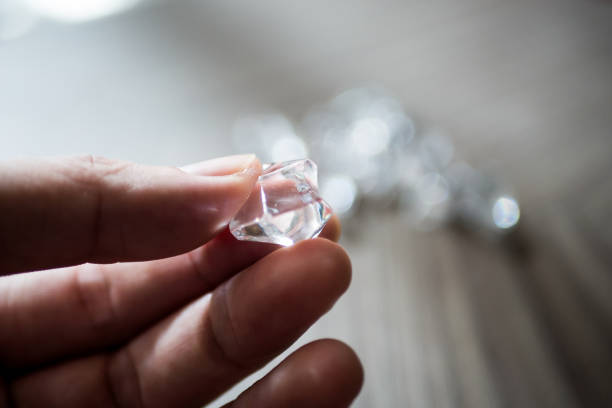 istock Male hand holding shiny diamond. 1196598483