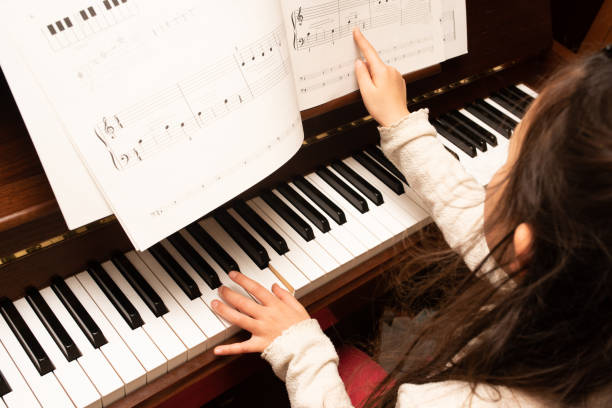 girl practicing the piano - practicing piano child playing imagens e fotografias de stock