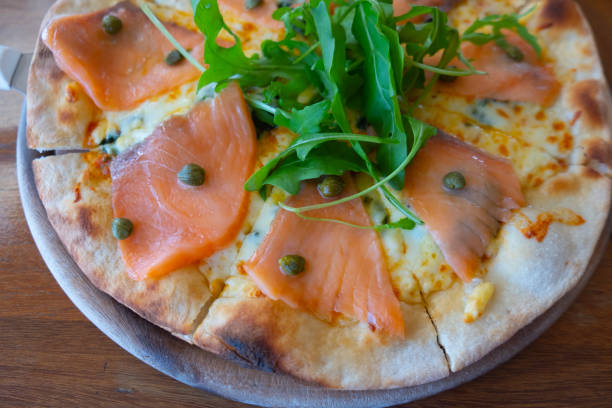 istock Pizza with smoke salmon on wood plate 1196614380