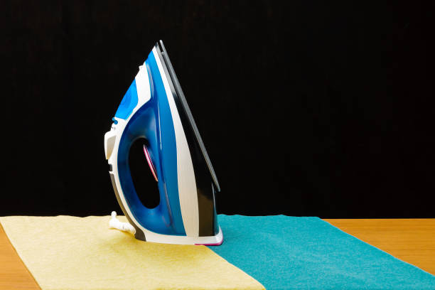istock The iron on a black mirror background with copy space 1196618183