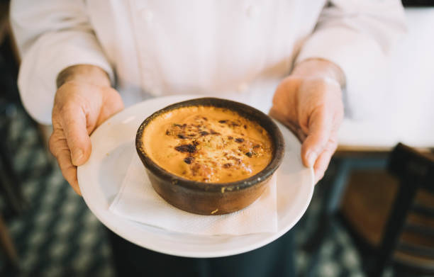 Chef Hands holding provaleta - grilled provolone cheese, a traditional Argentinian dish.