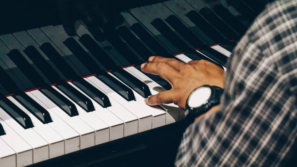 istock Close Up of Hand Playing Piano 1196624610