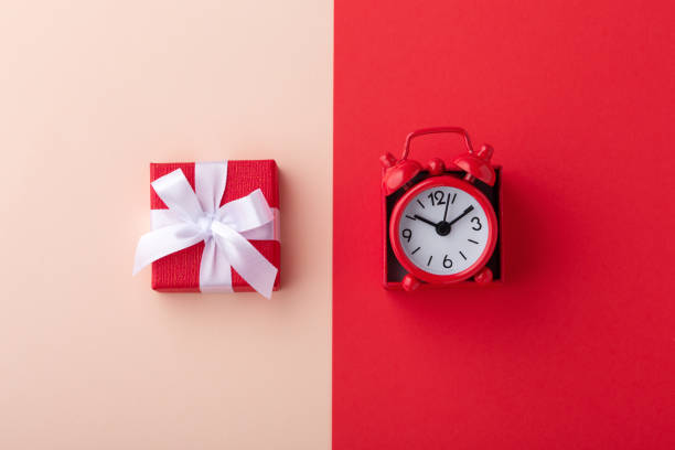 istock Gift box and red clock on pink and red background 1196628318