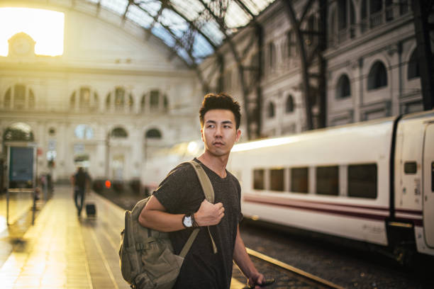 istock Young man on the railway station 1196631071