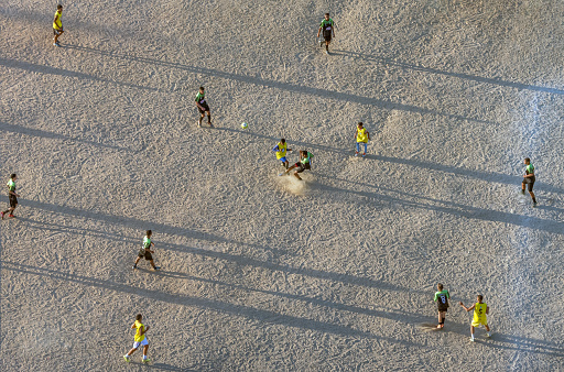 Pina district, Recife, Pernambuco, Brazil - December 26,2019:Young men having fun and playing soccer in a clay field.