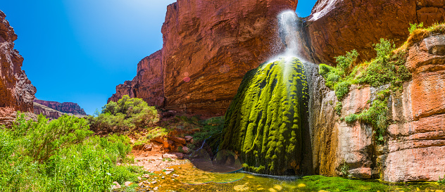 The cool clear water of Ribbon Falls cascading into its green mossy oasis hidden on the North Kaibab Trail of the Grand Canyon National Park, Arizona, USA.