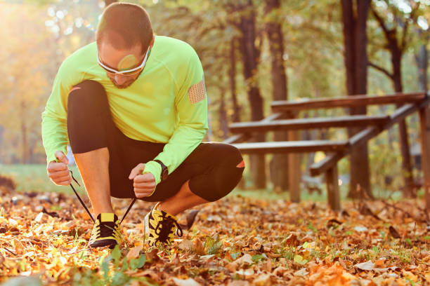 istock Preparing for jogging in autumn colored park. 1196636562