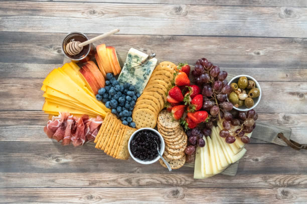 istock Gourmet cheese, crackers, and fruit on a wood cutting board served 1196641066