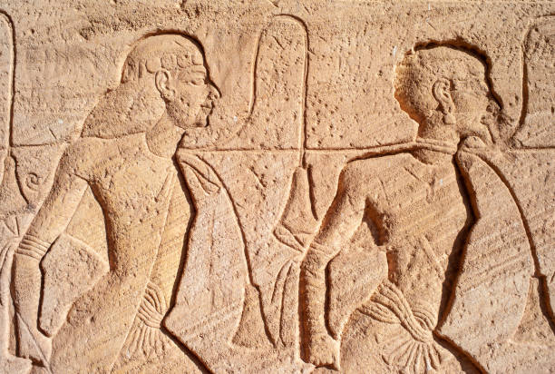Abu Simbel - Relief Detail with Slaves on the Great Temple Abu Simbel - Stone Relief Detail depicting Prisoner Slaves on the Great Temple of Ramesses II in Egypt ramses i stock pictures, royalty-free photos & images