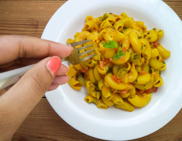 istock Close-up of hand taking macaroni past fork form a plate through fork. 1196647773