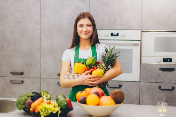 A girl smiling holding nutritious fruit and veg