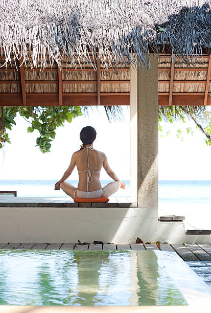 istock woman playing yoga in thatched pavilion 119665298