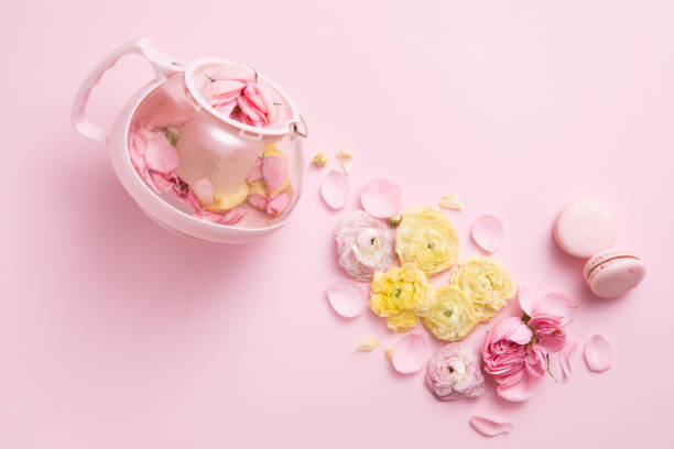 vista superior de la disposición creativa de tetera rosa y taza de té con flores sobre fondo rosa. - tea tea leaves jasmine tea leaf fotografías e imágenes de stock