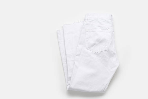 istock Folded white jeans on white background. Monochromatic flatlay 1196653643