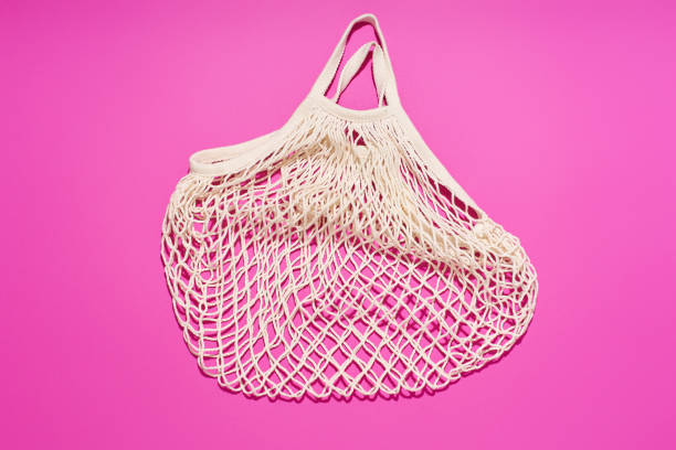 istock Textile net bag on bright purple background. Flatlay with flash light. Plastic free concept 1196653752