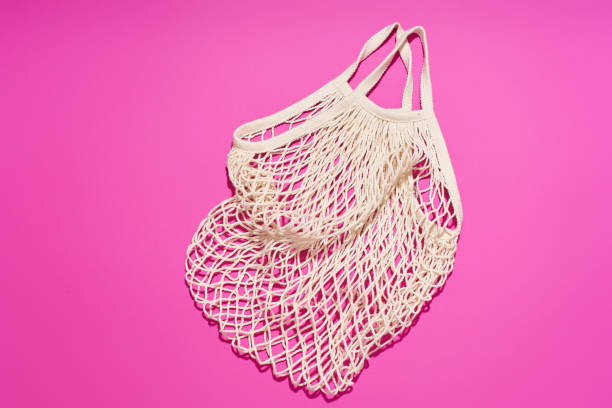 istock Textile net bag on bright purple background. Flatlay with flash light. Plastic free concept 1196653756