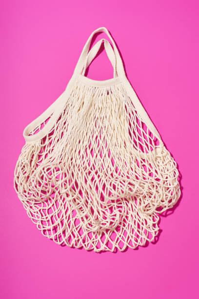 istock Textile net bag on bright purple background. Flatlay with flash light. Plastic free concept 1196653758