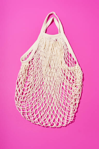 istock Textile net bag on bright purple background. Flatlay with flash light. Plastic free concept 1196653786