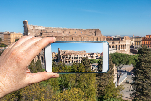 tourist taking photo of the Ancient Roman Colosseum, Rome, Italy