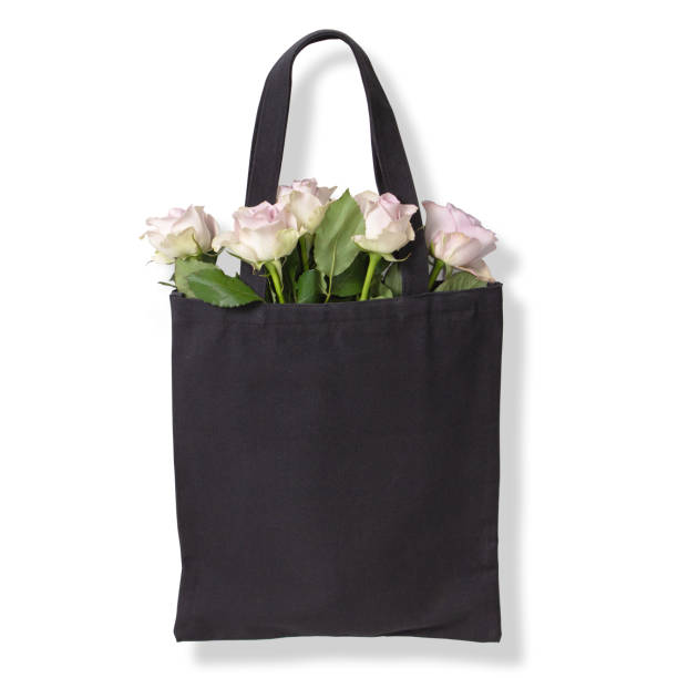istock Black cotton tote bag with light violet roses inside. Isolated on white background 1196659990