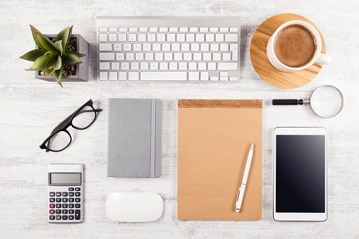 Business table top with office supplies on white wooden table background