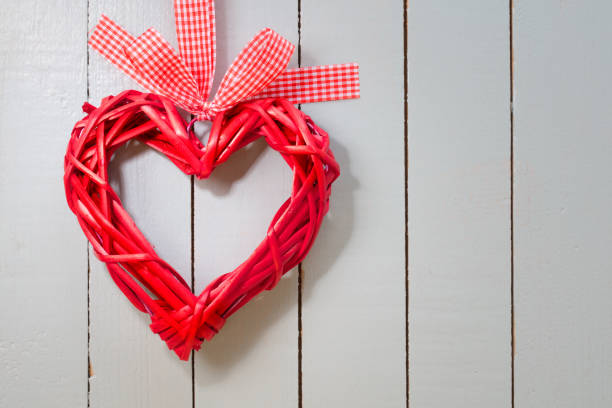 Red wicker heart on a gray painted wooden background. Space for copy.
