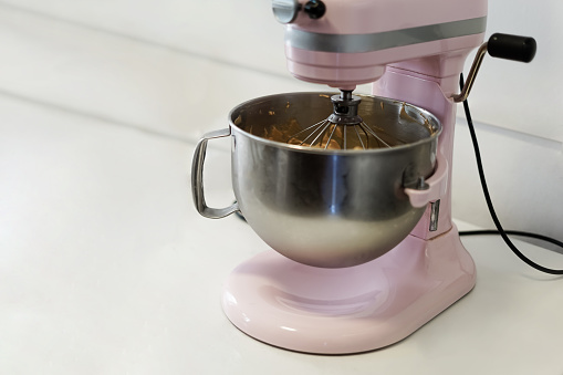 Close-up of a pink Stand Mixer, mixing something. Cooking concept.