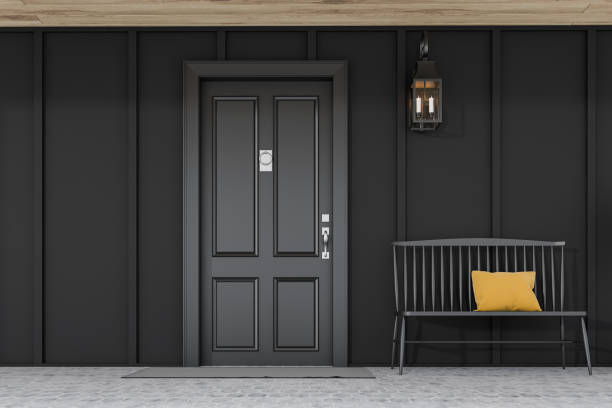 istock Black front door of black house with bench 1196682543