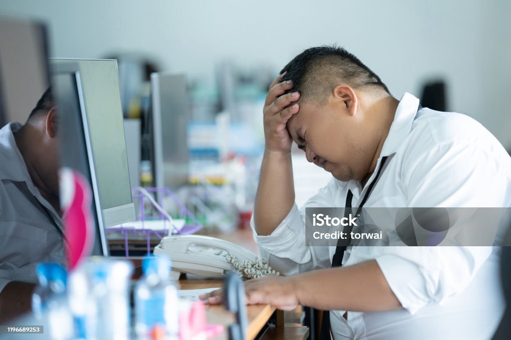 The employee was unemployed and was fired. He was in a feeling of regret and headache. Overweight Stock Photo
