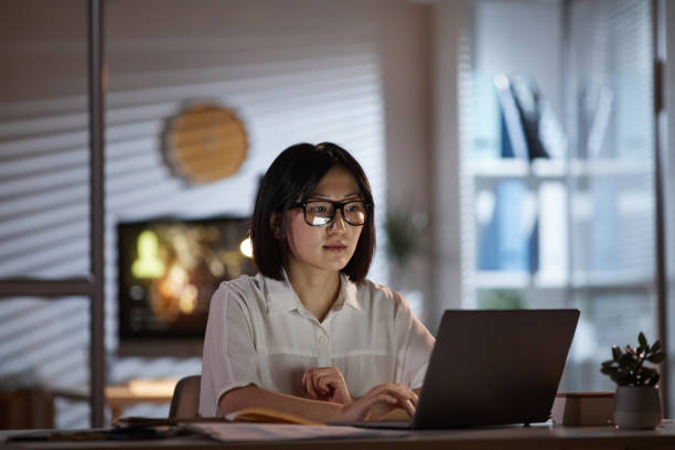istock Woman working late at office 1196691145