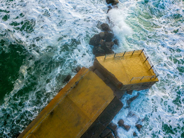 海に岩や岩がある桟橋の空中写真。ピッツォ・カラブロ桟橋からパノラマの景色を望めます。壊れた桟橋、海の力。 - rock overhang ストックフォトと画像
