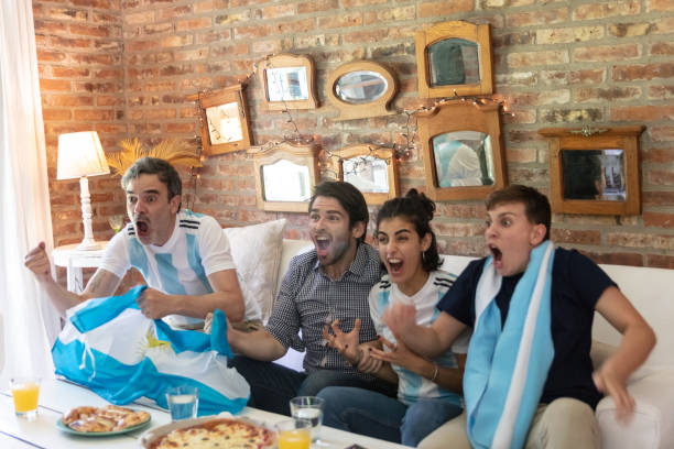 grupo argentino alegre de amigos viendo partidos de fútbol en la televisión, celebrar un gol - argentina mundial fotografías e imágenes de stock