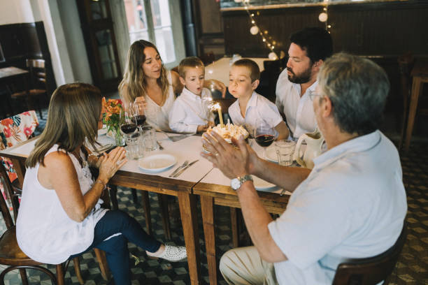 istock Boy blowing out burthday candle 1196702580