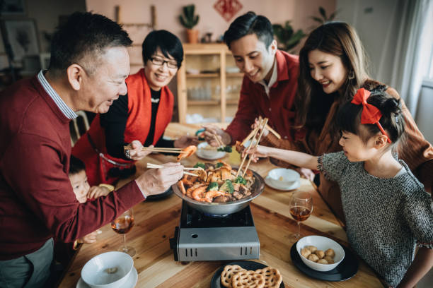drei generationen von fröhlichen asiatischen familie feiern chinesisches neujahr und genießen traditionelle chinesische poon choi auf wiedersehen abendessen - chinesisches neujahr fotos stock-fotos und bilder