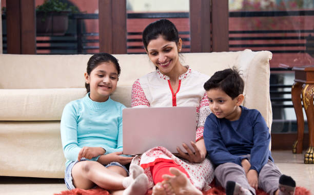 istock Mother with children using laptop at home 1196703366