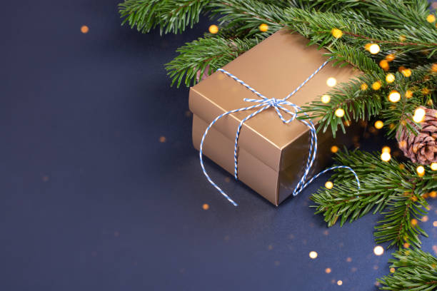 istock Golden gift box near pine tree branches 1196706620