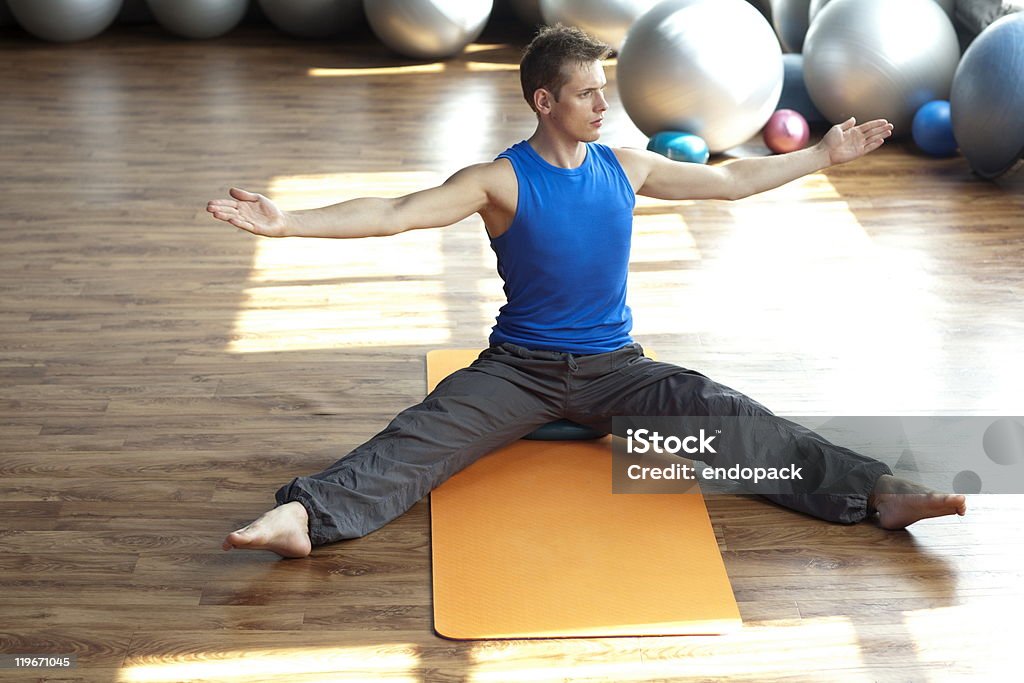 Fusão da mente e do corpo-homem praticando pilates - Foto de stock de Academia de ginástica royalty-free