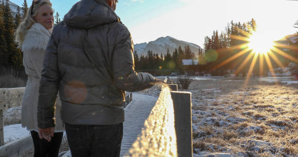 istock Mature couple walk along boardwalk in winter 1196710471