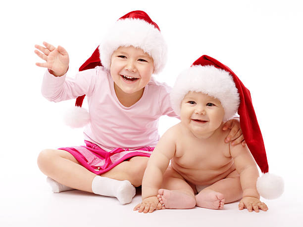 istock Two children wearing red Christmas caps and smile 119671052
