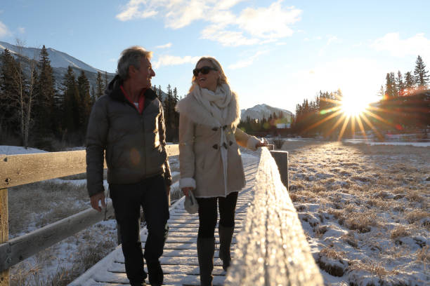 istock Mature couple walk along boardwalk in winter 1196710608