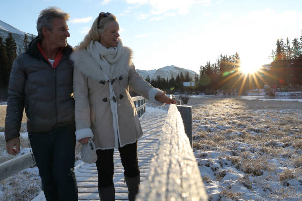 istock Mature couple walk along boardwalk in winter 1196710661